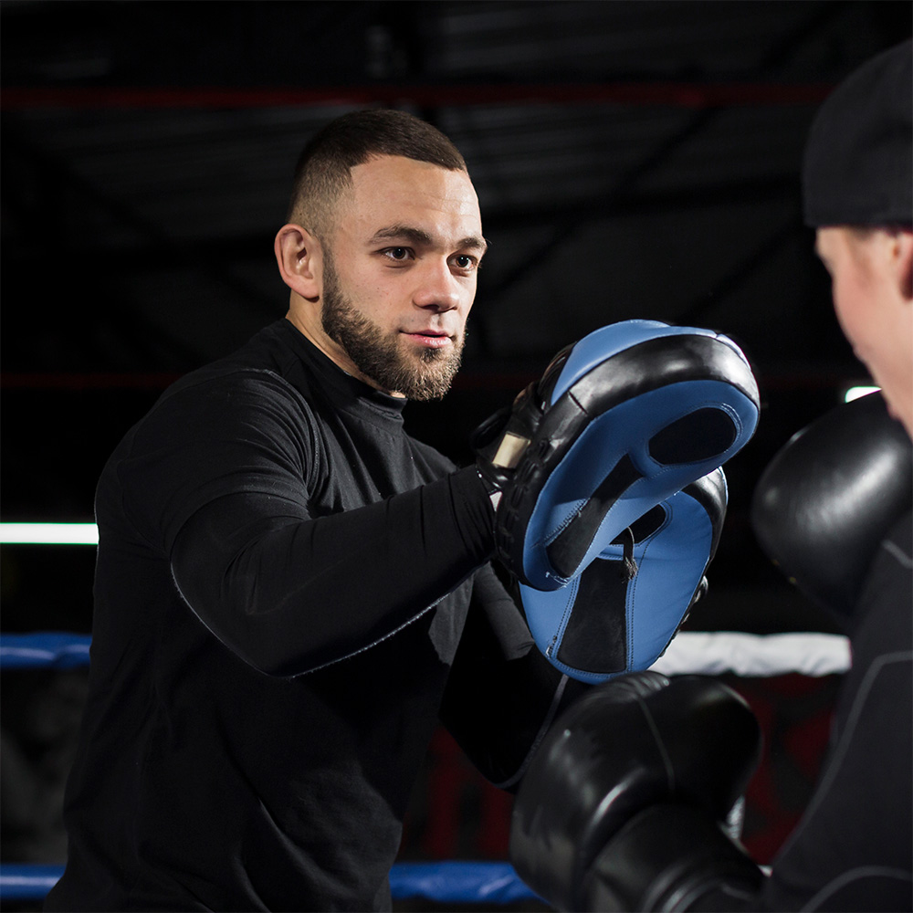 female-boxer-with-protective-gloves-practicing-with-trainer